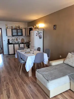 a kitchen and a dining room with a table and a refrigerator at Apartament in Aheloy in Aheloy