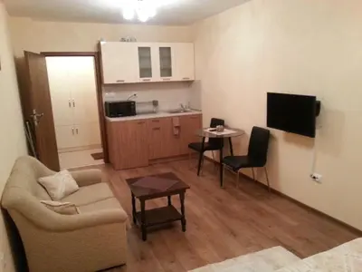 a living room with a couch and a tv and a table at Studio Zora in Burgas City