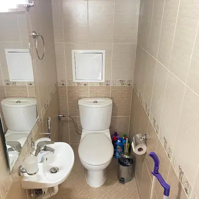 a small bathroom with a toilet and a sink at Тристаен апартамент в затворен комплекс in Chernomorets