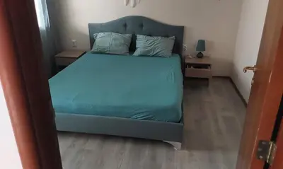 a bed with blue sheets and pillows in a room at Etara 2 Apartment in Sveti Vlas