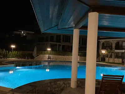 a swimming pool at night with chairs and a building at Etara 2 Apartment in Sveti Vlas