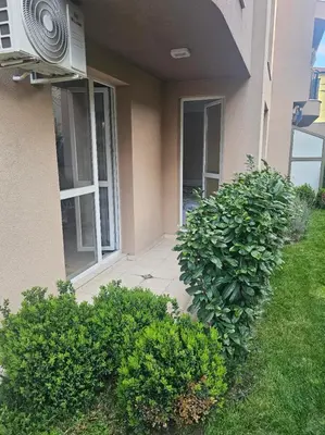 a house with bushes in front of a building at Релакс в Равда! in Ravda