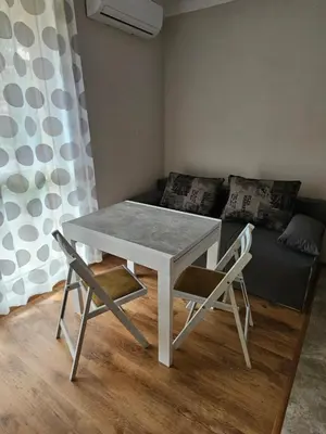 a white table and chairs in a room with a couch at Релакс в Равда! in Ravda