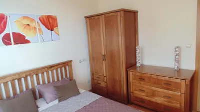 a bedroom with a wooden bed and a dresser at Garden of Eden in Sveti Vlas