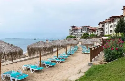 a row of chairs and umbrellas on a beach at Garden of Eden in Sveti Vlas