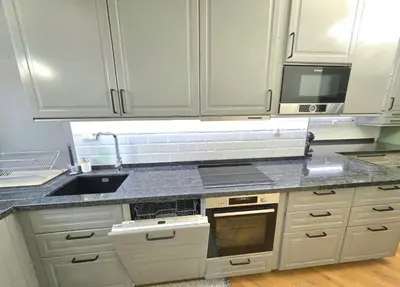 a kitchen with white cabinets and a sink at Seaside Apartment in Varna City
