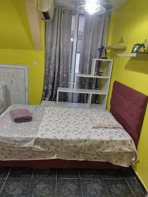 a small bedroom with a bed and a window at Pomponi in Burgas City