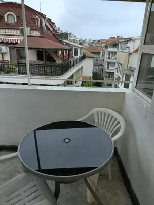 a table and a chair on a balcony at Pomponi in Burgas City