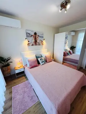 a bedroom with a large bed and a mirror at Апартаменти Sozopol Residence in Sozopol
