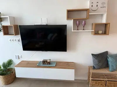 a living room with a large flat screen tv on a wall at Апартаменти Sozopol Residence in Sozopol