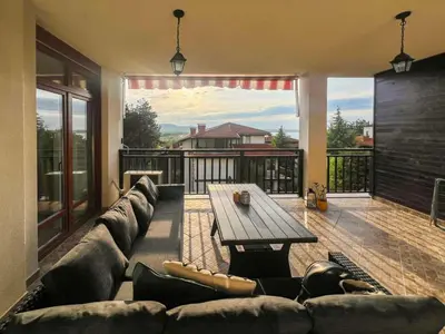 a living room with a couch and a wooden table at Lavender Apartment in Sozopol