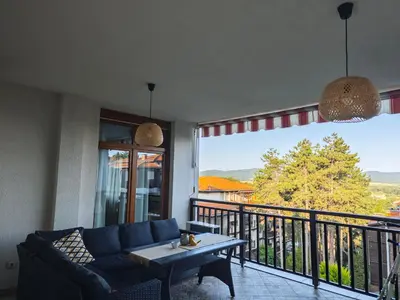a living room with a couch and a table on a balcony at Lavender Apartment in Sozopol