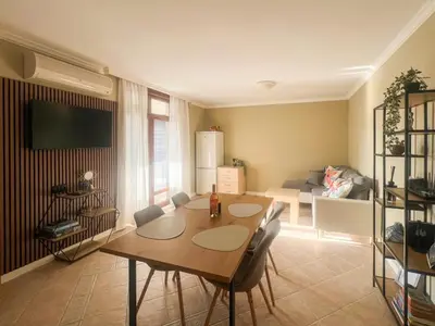 a living room with a table and chairs and a couch at Lavender Apartment in Sozopol