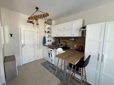 a kitchen with white cabinets and a wooden table at Casa del Sol in Sunny Beach