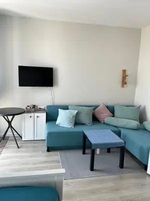 a living room with a blue couch and a tv at Casa del Sol in Sunny Beach