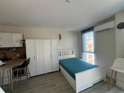 a bedroom with a bed and a table and a window at Casa del Sol in Sunny Beach
