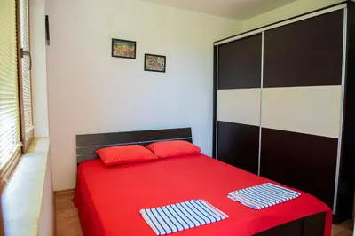 a bedroom with a red bed with two towels on it at 