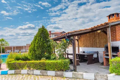 a backyard with a wooden pergola and a table at 
