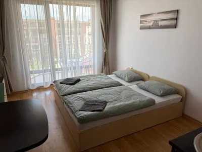 a bed in a room with a large window at Private Apartment 171 in Prestige Fort Beach Hotel in Sveti Vlas