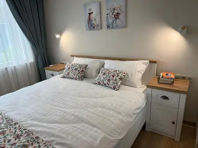 a bedroom with a large white bed with two pillows at Smile Old City Apartment with Free parking and Sea view in Varna City