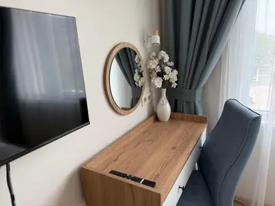 a living room with a television and a vase of flowers on a table at Smile Old City Apartment with Free parking and Sea view in Varna City