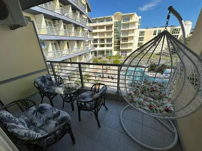 a balcony with chairs and a bird cage with flowers at Дрийм 2 Мечта 2 in Sunny Beach