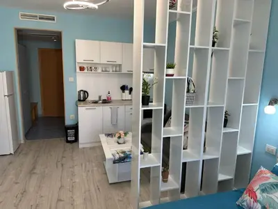 a living room with white shelves in a room at Дрийм 2 Мечта 2 in Sunny Beach