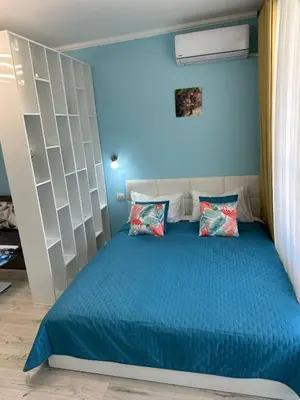 a blue bedroom with a bed with two pillows at Дрийм 2 Мечта 2 in Sunny Beach