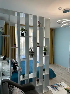a living room with white shelves with potted plants at Nana Studio Sunny Beach in Sunny Beach