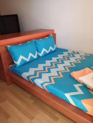 a bed with blue sheets and blue pillows at Kasndra in Byala