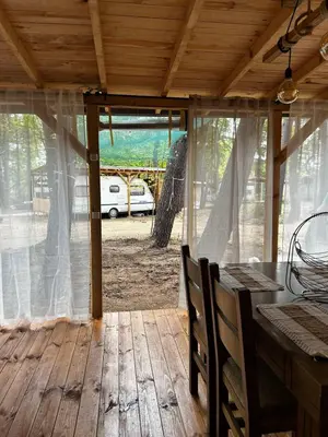 a screened in porch with a table and chairs at Нереида in Sozopol