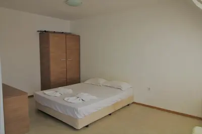 a bedroom with a bed and a wooden cabinet at Belle View - Menada Apartments in Sveti Vlas