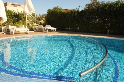 a large swimming pool with blue water in a yard at Belle View - Menada Apartments in Sveti Vlas
