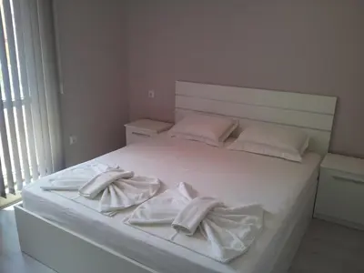 a white bed with two towels on top of it at Apartment Zlatina in Pomorie