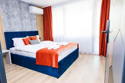 a bedroom with a bed with orange and blue at Boulevard Hotel in Aytos