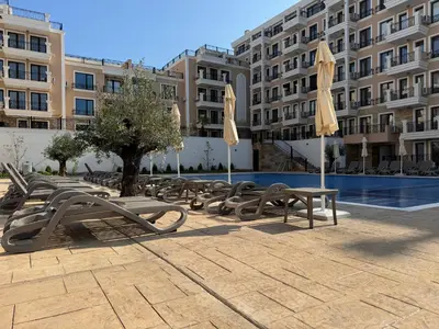 a group of chairs and umbrellas next to a pool at Apartment Summer Vibes in Sveti Vlas