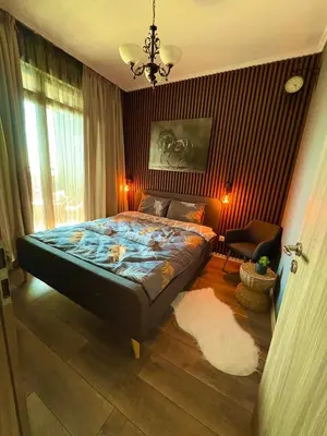 a bedroom with a bed and a chair in it at Sea View Apartments Residence Лазурен бряг in Burgas City
