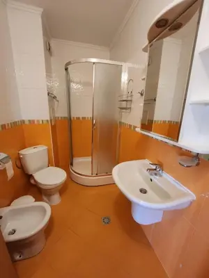 a bathroom with a shower and a toilet and a sink at Лукс Апартамент Лазур с безплатен паркинг in Pomorie