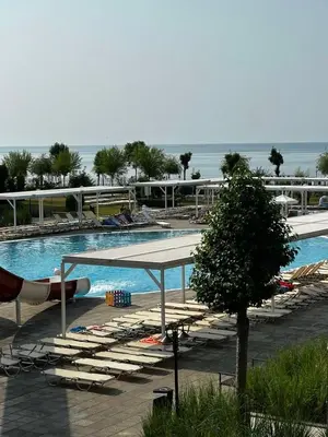 a large swimming pool with lounge chairs and a tree at Premier Fort Beach Hotel in Sveti Vlas