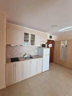 a kitchen with white cabinets and a white refrigerator at Premier Fort Beach Apartment with Pool & Sea View in Sveti Vlas