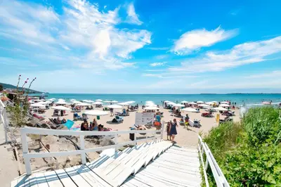 a group of people on a beach with the ocean at Premier Fort Beach Apartment with Pool & Sea View in Sveti Vlas