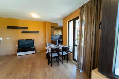 a dining room with a table with chairs and a television at GGeorgi Sarafovo in Burgas City