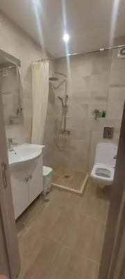 a bathroom with a shower and a toilet and a sink at Condo Santosha on the beach in Pomorie