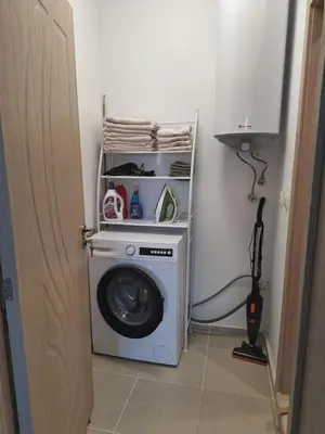 a washing machine in a corner of a room at Condo Santosha on the beach in Pomorie