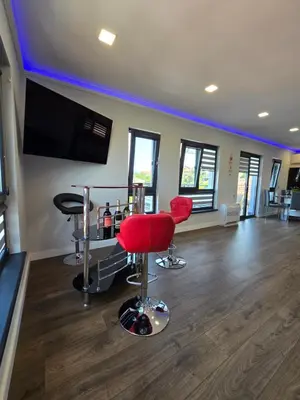 a barber shop with red chairs and a flat screen tv at Къща Холидей Обзор in Obzor