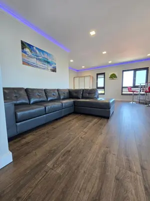 a large living room with a black leather couch at Къща Холидей Обзор in Obzor