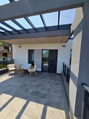a patio with a glass roof with a table and chairs at Къща Холидей Обзор in Obzor