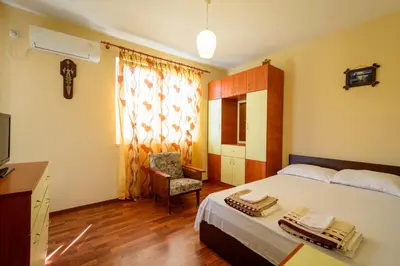 a bedroom with a bed and a chair and a television at Apartment Yanevi in Lozenets