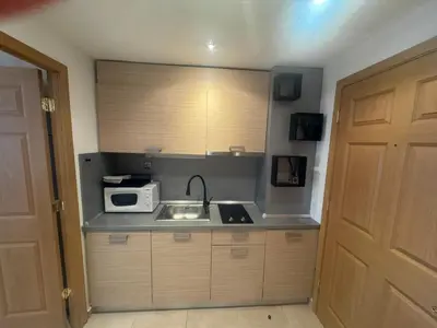 a small kitchen with a sink and a microwave at STUDIO 46 South Pearl Homes in Sozopol