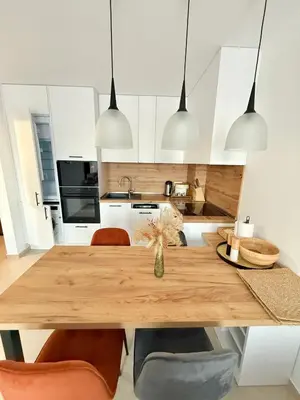 a kitchen with a wooden table and chairs at Polarstar Apartment in Sveti Vlas